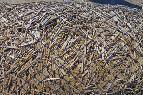 close up detail of erosion control wattle netting filled with straw