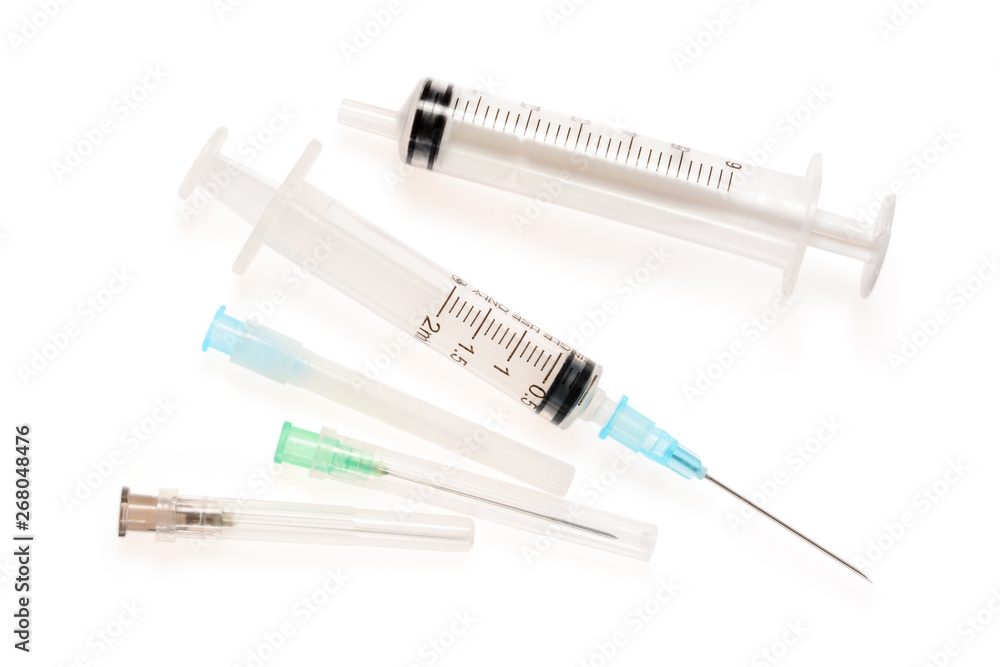 Two syringes and three needles. 2 and 6 ml disposable syringe close up, isolated on white background with shadow Two syringes and three needles. 2 and 6 ml disposable syringe close up, isolated on white background with shadow