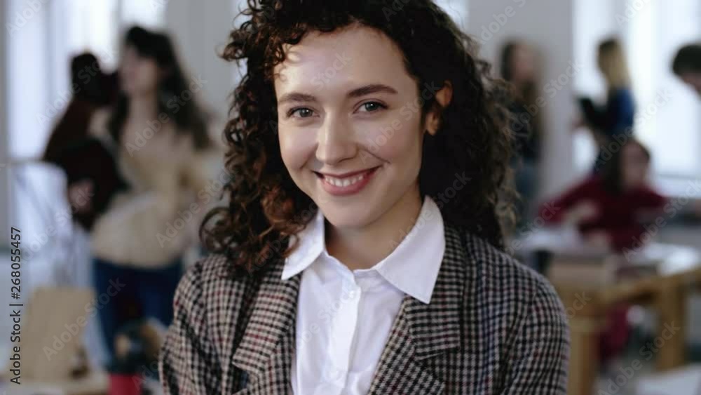 Close-up shot of happy European young entrepreneur business woman smiling cheerfully with curly hair at modern office. Close-up shot of happy European young entrepreneur business woman smiling cheerfully with curly hair at modern office.