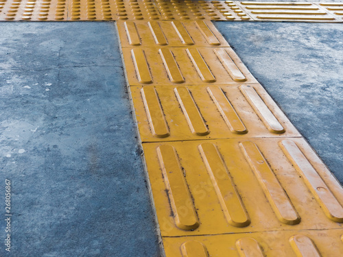 Intersection of Tactile Paving on Ground Surface as Guidance or Warning Sign To Help Visually Impaired or Blind Pedestrians. Yellow Truncated Domes Block Walking Indicator on Train or Subway Station