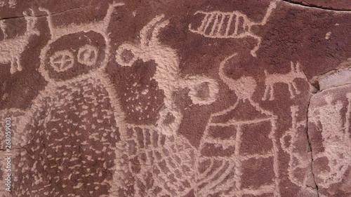 Panning up close view of petroglyph carvings in rock wall made from native americans in Utah long ago in Nine Mile Canyon.