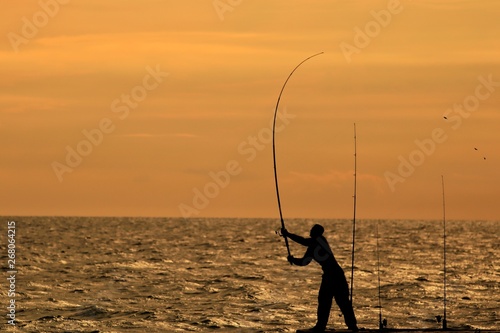 The angler is fishing while the sun is falling