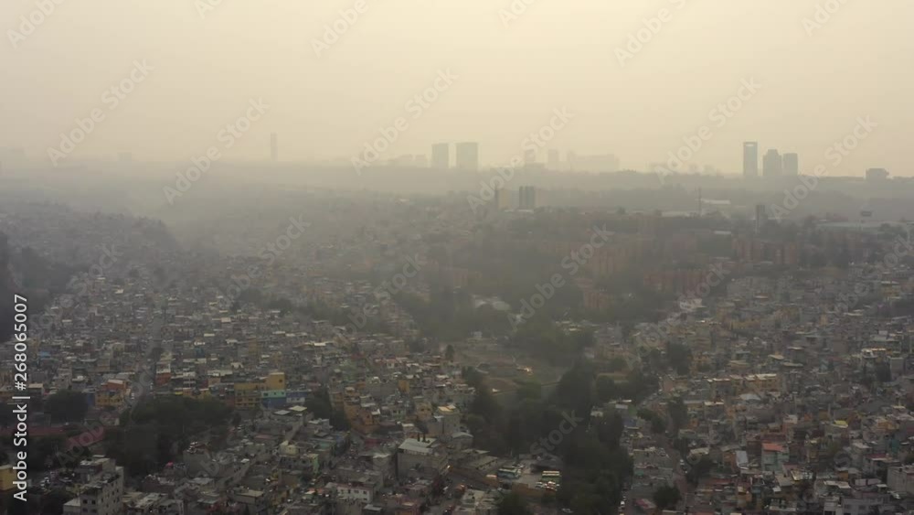 Aerial drone shot of big urban settlements in ravines in a very polluted day in Mexico City Aerial drone shot of big urban settlements in ravines in a very polluted day in Mexico City