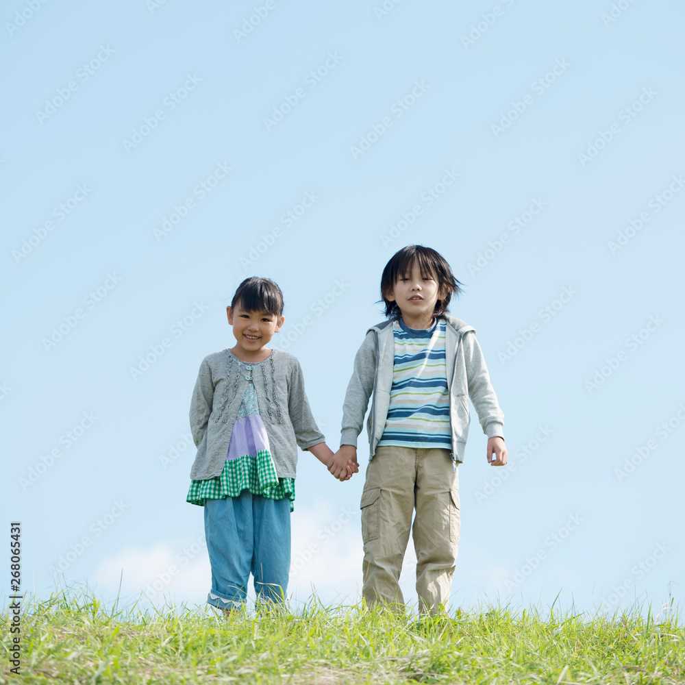草原で手をつなぐ小学生 草原で手をつなぐ小学生