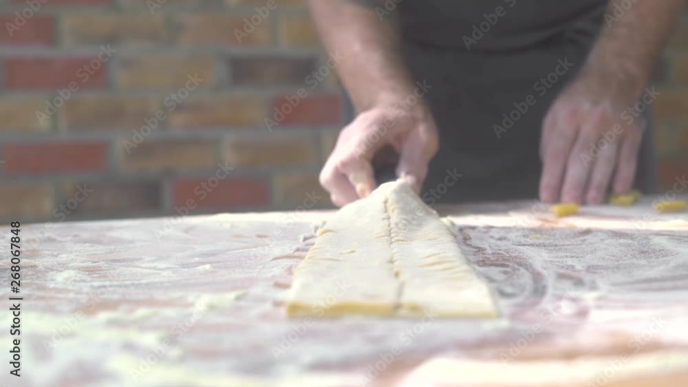 Chef cook making fresh pasta on master class. Process preparation homemade italian pasta by traditional recipe. Cooking homemade food. Italian cuisine. Rustic background. Chef cook making fresh pasta on master class. Process preparation homemade italian pasta by traditional recipe. Cooking homemade food. Italian cuisine. Rustic background.