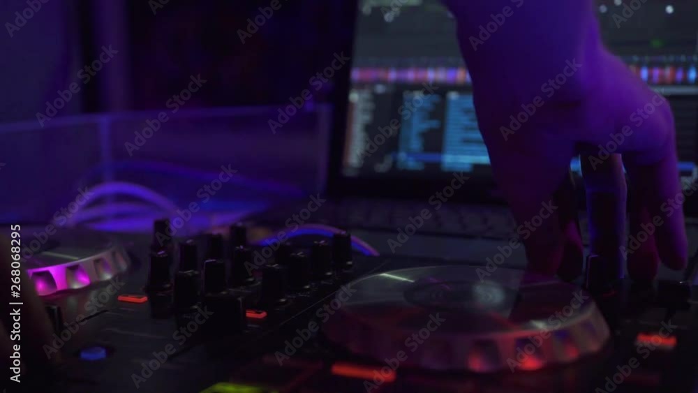 DJ console for mixing dance music and laptop in disco club. DJ mixer player and sound console for dance party. Close up disc jockey controller with music equalizer on mixing deck in nightclub. DJ console for mixing dance music and laptop in disco club. DJ mixer player and sound console for dance party. Close up disc jockey controller with music equalizer on mixing deck in nightclub.