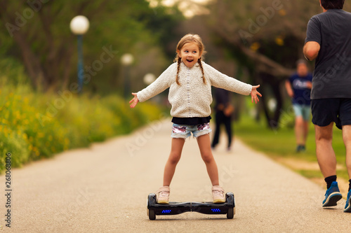 Beautiful little girl riding the GyroScooter in the park