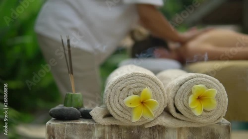 close-up towels with yellow flowers and burning incense sticks outdoors Spa