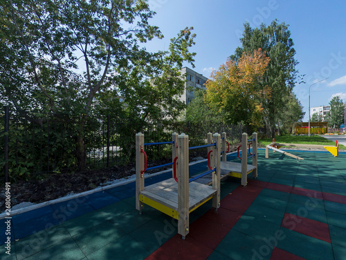 children's playground with green and red softfall rubber surface © flyural66