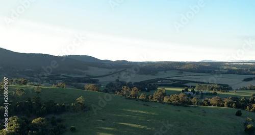 Part 5 of 5 of beautiful and stunning drone flight rising up and over a flourishing green hill revealing a picturesque valley in low afternoon light. 5 of 5 clips - can be joined. photo