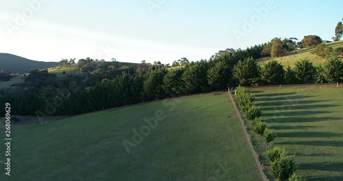 Part 1 of 5 of beautiful and stunning drone flight rising up and over a flourishing green hill revealing a picturesque valley in low afternoon light. 1 of 5 clips - can be joined. photo