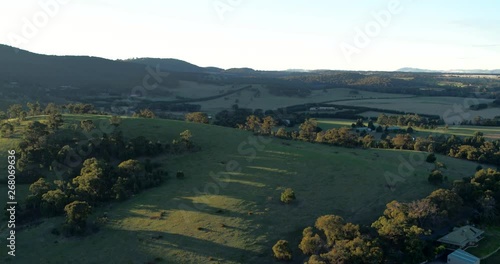 Part 1 of 2 of fast reversing and descending drone footage returning from above a beautiful rural hill in late afternoon light. 1 of 2 clips - can be joined. photo