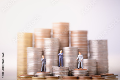 Fotografie Miniature people:  Small businessmans figures standing on turning poing