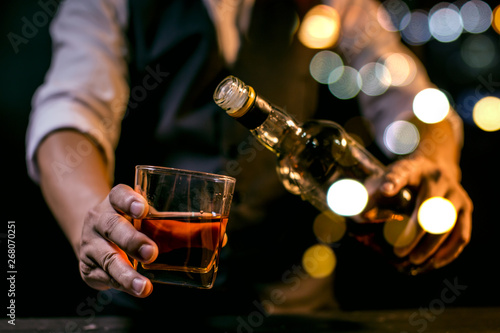 hand with glass of whiskey and cigar