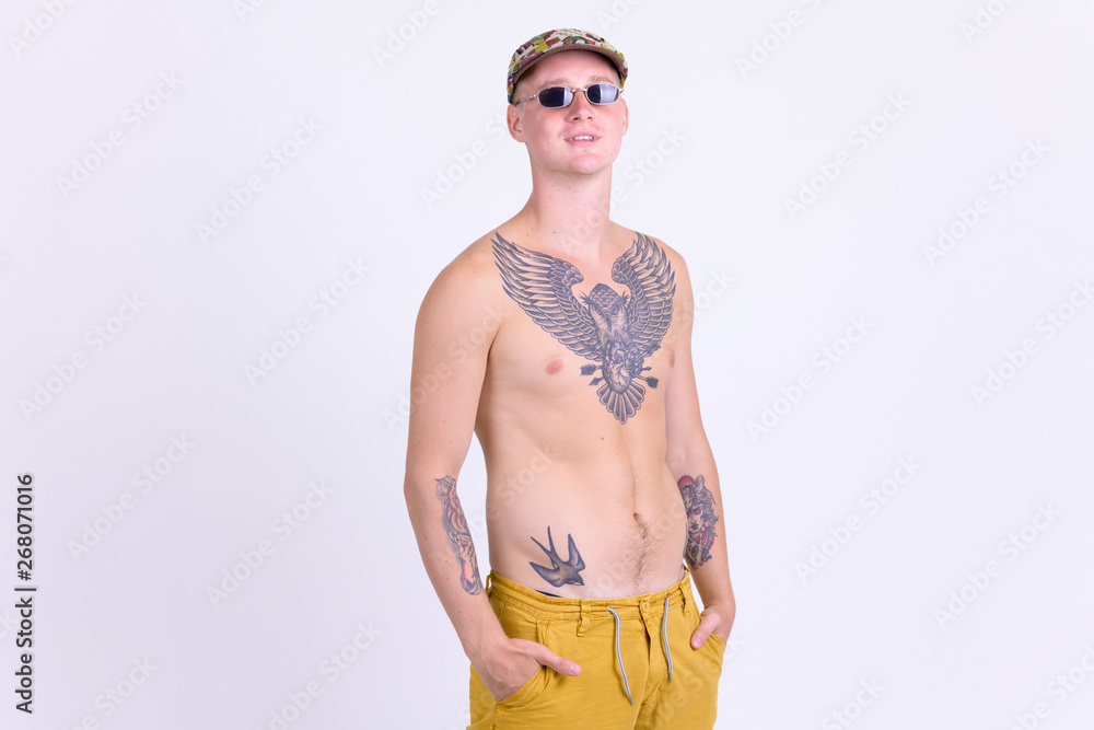 Young handsome shirtless man with tattoos looking at camera Young handsome shirtless man with tattoos looking at camera