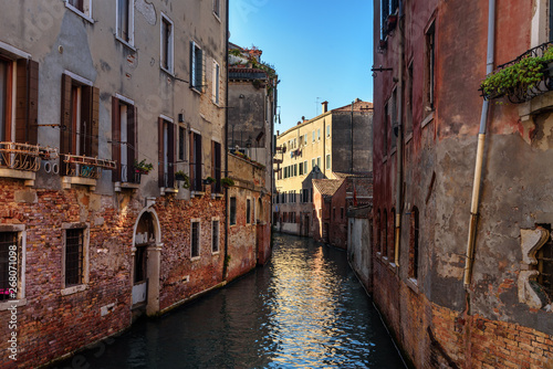 Narrow canal among old brick houses. Venice. Italy.