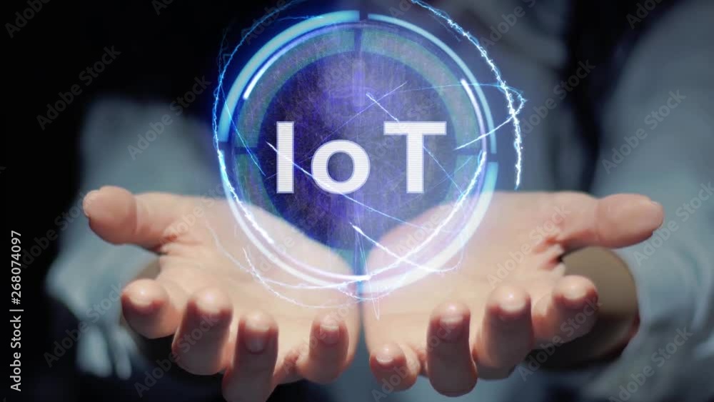 Female hands show a round conceptual hologram with text IoT. Unrecognizable woman in ashen white on a black background with future holographic technology Female hands show a round conceptual hologram with text IoT. Unrecognizable woman in ashen white on a black background with future holographic technology