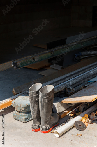 Gum boots placed next to construction debris. photo