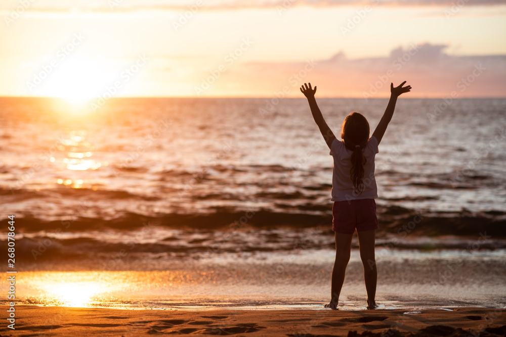 Carefree little girl standing at the edge of sea wave