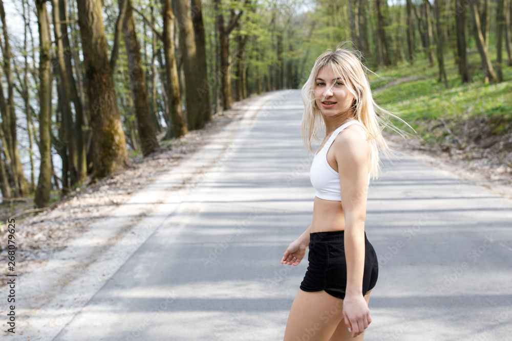 A young, pretty girl blonde runs outdoors in the woods near the lake with beautiful scenery. Sports activity. Exercise Outdoors. Health and benefits for the body A young, pretty girl blonde runs outdoors in the woods near the lake with beautiful scenery. Sports activity. Exercise Outdoors. Health and benefits for the body
