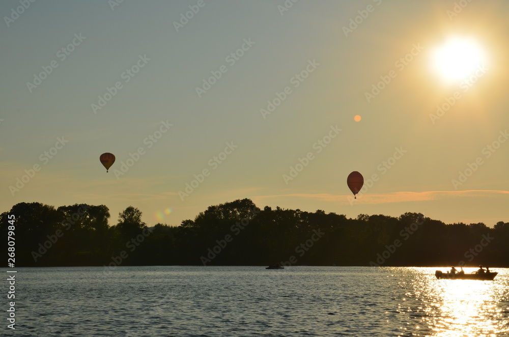 Hot air balloons over a lake in Poland view during sunset Hot air balloons over a lake in Poland view during sunset