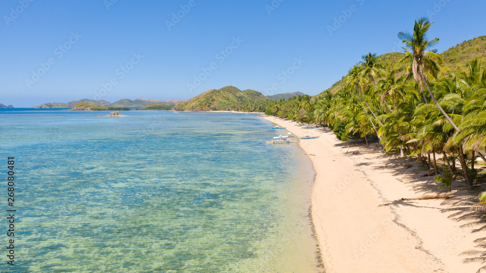 Tropical white sand beach. Island with a blue lagoon. Boats and people off the coast of a tropical island.Vacation on a tropical beach, top view aerial view