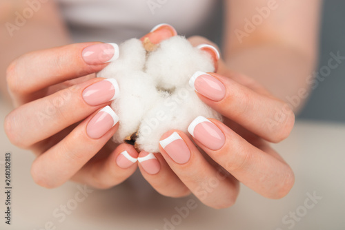 Woman hands holding delicate white cotton flower
