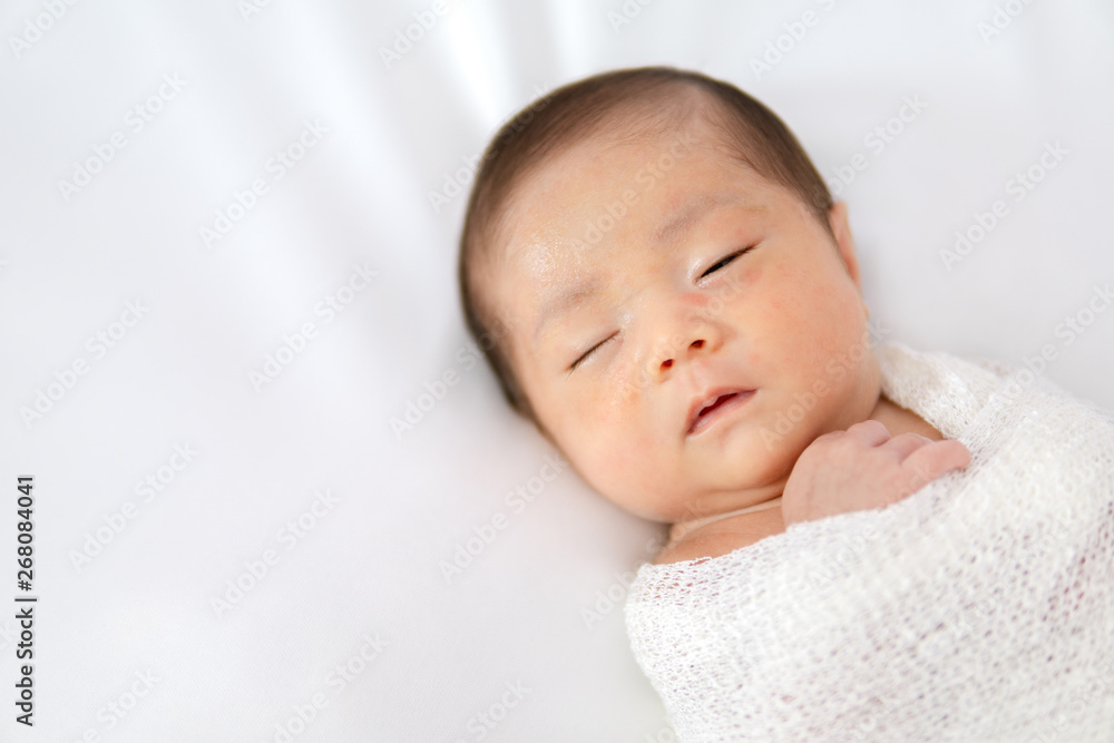 Sleeping newborn baby in white wrap while on white blanket background. Sleeping newborn baby in white wrap while on white blanket background.
