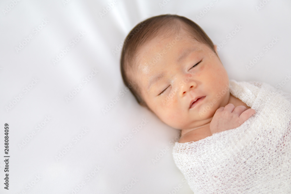 Sleeping newborn baby in white wrap while on white blanket background. Sleeping newborn baby in white wrap while on white blanket background.