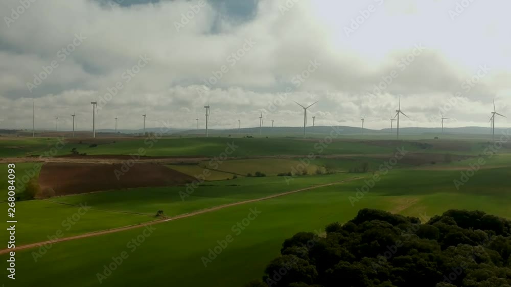 A drone shot flying over a trees near a wind farm A drone shot flying over a trees near a wind farm