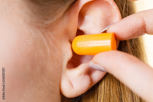 Woman putting earplugs