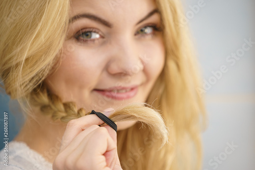 Woman making braid on blonde hair