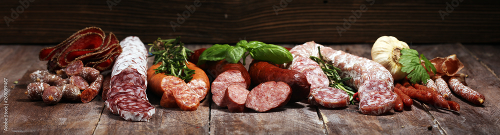 cold meat assortment with delicious salami and  fresh herbs . Variety of meat products including coppa and sausages