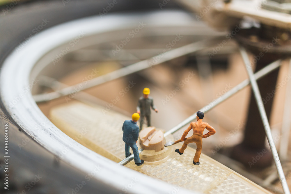 Miniature people : mechanics repairing bicycle Miniature people : mechanics repairing bicycle