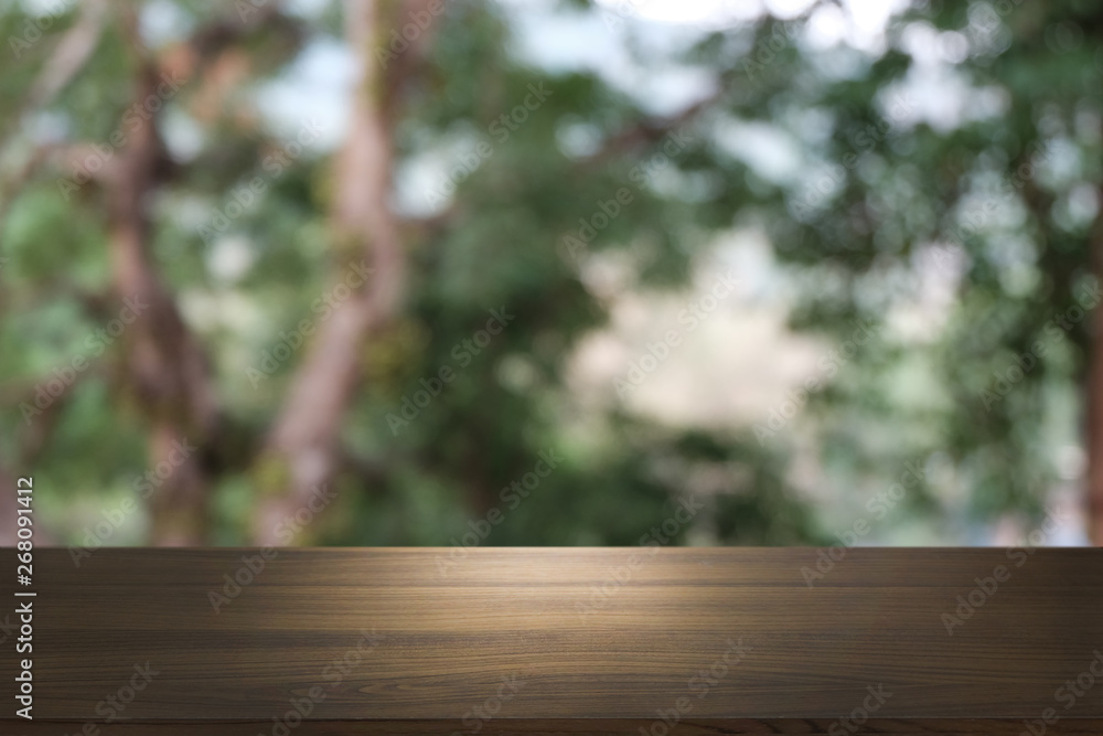 Image of wooden table in front of abstract blurred background of outdoor garden lights. can be used for display or montage your products.Mock up for display of product. Image of wooden table in front of abstract blurred background of outdoor garden lights. can be used for display or montage your products.Mock up for display of product.