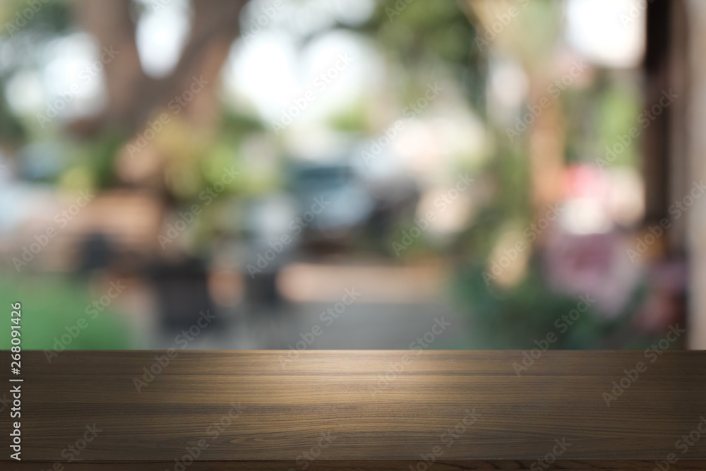 Image of wooden table in front of abstract blurred background of outdoor garden lights. can be used for display or montage your products.Mock up for display of product.