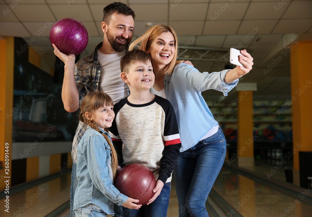 Fototapeta premium Family taking selfie at bowling club