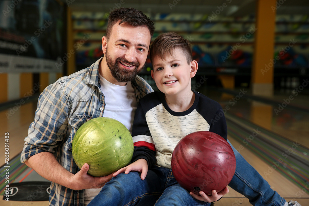 Fototapeta premium Man with his little son in bowling club