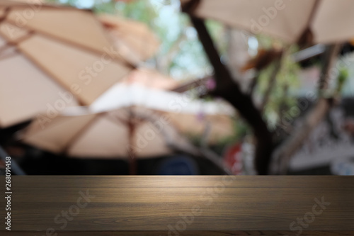 Empty dark wooden table in front of abstract blurred bokeh background of restaurant . can be used for display or montage your products.Mock up for space.