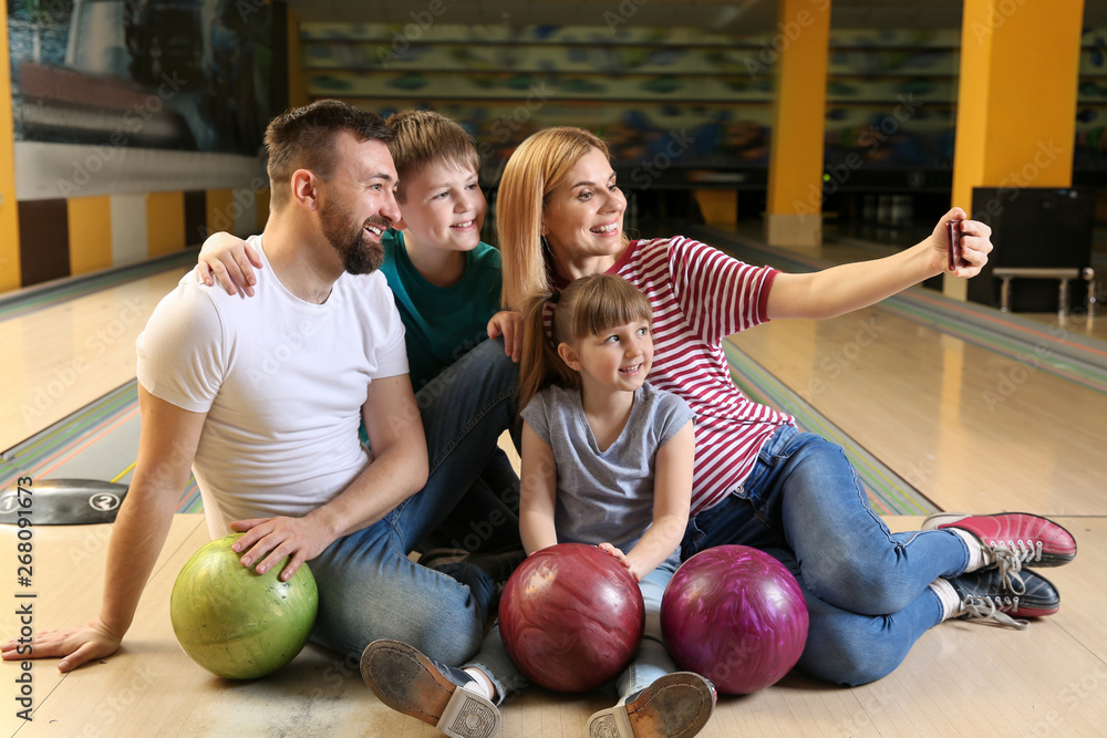 Fototapeta premium Family taking selfie in bowling club