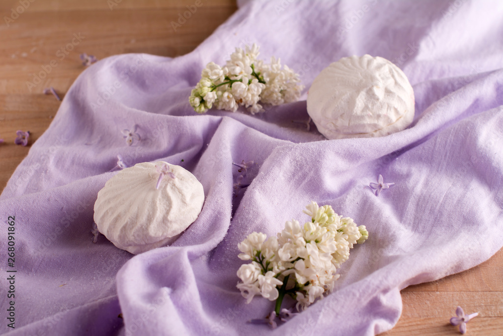 white marshmallow and flowers on purple fabric on the table white marshmallow and flowers on purple fabric on the table