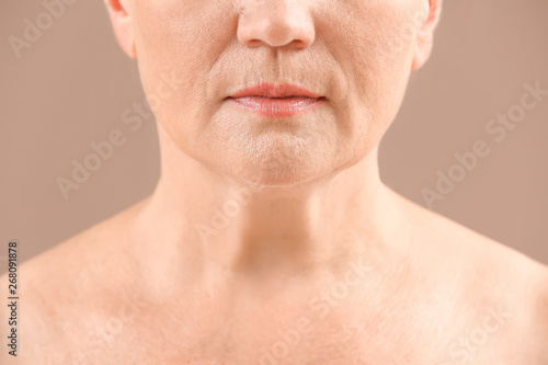 Mature woman on color background, closeup