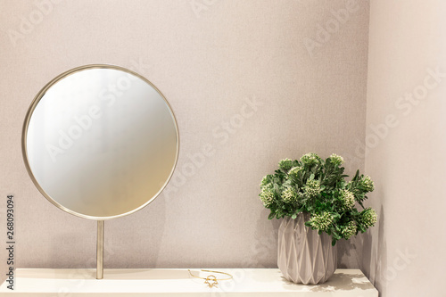 Fototapeta Round mirror frame and House plant on white dressing table