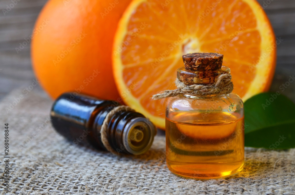 Orange essential oil in a glass bottle and fresh fruits on old wooden table.Citrus oil for skin care, spa, wellness, massage, aromatherapy and natural medicine.Selective focus.Copy space. Orange essential oil in a glass bottle and fresh fruits on old wooden table.Citrus oil for skin care, spa, wellness, massage, aromatherapy and natural medicine.Selective focus.Copy space.