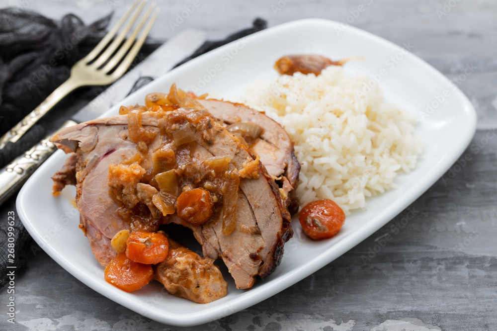 baked turkey leg with vegetables, smoked sausage, herbs and boiled rice on white dish baked turkey leg with vegetables, smoked sausage, herbs and boiled rice on white dish