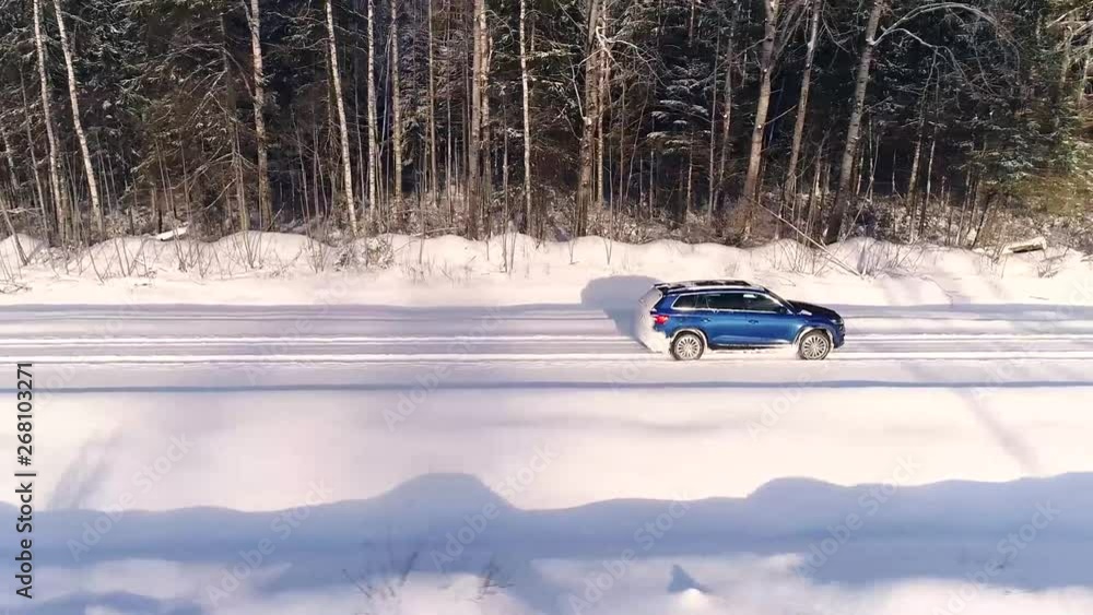 Aerial view of a car driving in the snowy forest in Estonia Aerial view of a car driving in the snowy forest in Estonia