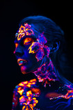 Beautiful flowers in UV light on a young girl face and body