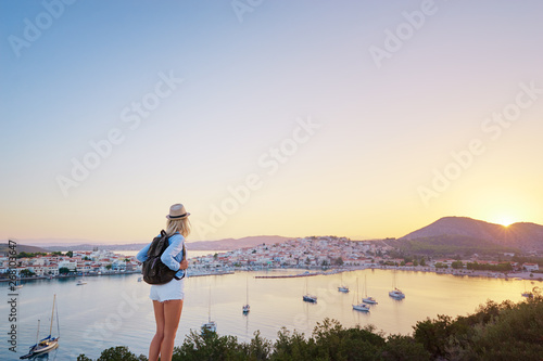 Enjoying vacation in Greece. Young traveling woman enjoying sunset on sea view point. © luengo_ua