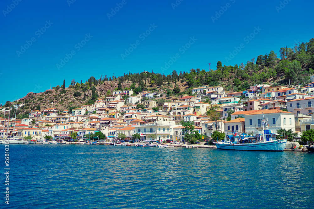 Naklejka premium Scenic view of Poros island in a typical summer day. Old town with traditional white houses near the sea. Saronic gulf, Greece, Europe.