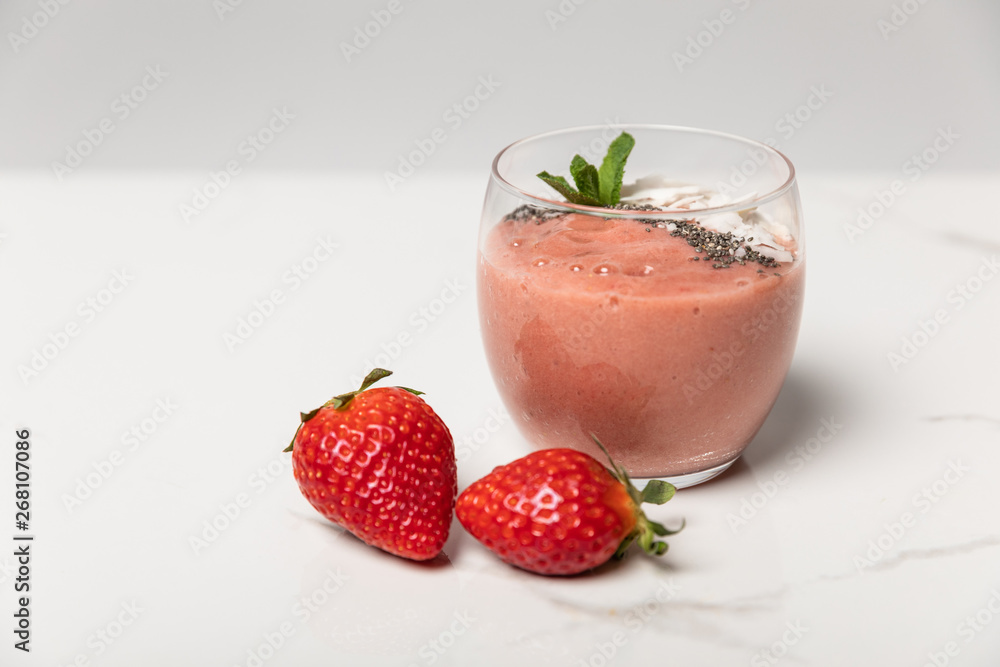 sweet ripe strawberries near tasty smoothie in glass on white sweet ripe strawberries near tasty smoothie in glass on white